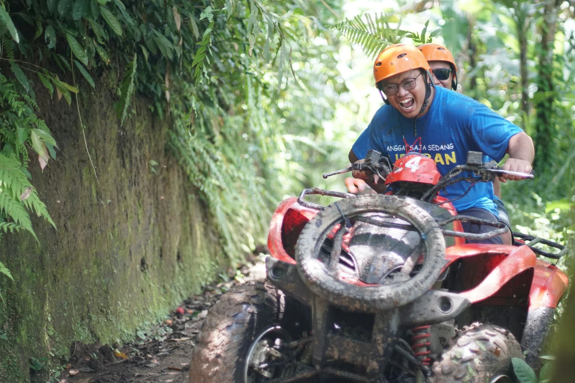 ATV rider navigating a muddy jungle trail through rainforest above Quepos near Manuel Antonio, Costa Rica