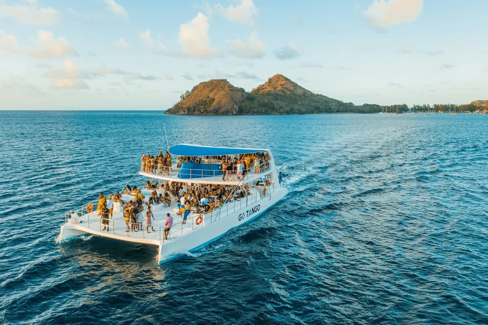 Catamarán de vela anclado en una bahía tranquila cerca de Tamarindo al atardecer con personas haciendo snorkel