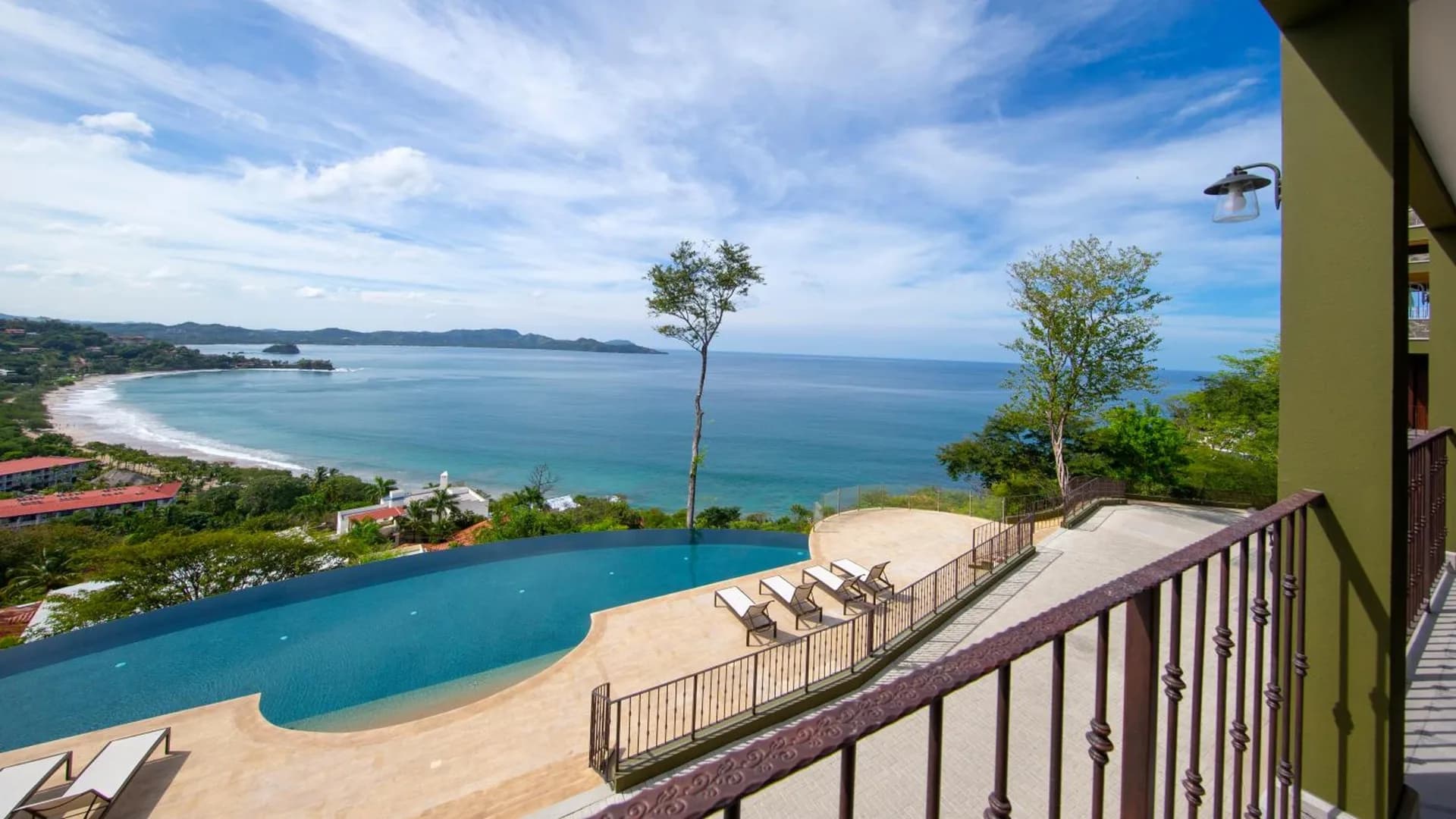 Piscina infinita en la loma sobre Playa Flamingo mirando al norte hacia la bahía y la arena blanca, Guanacaste, Costa Rica