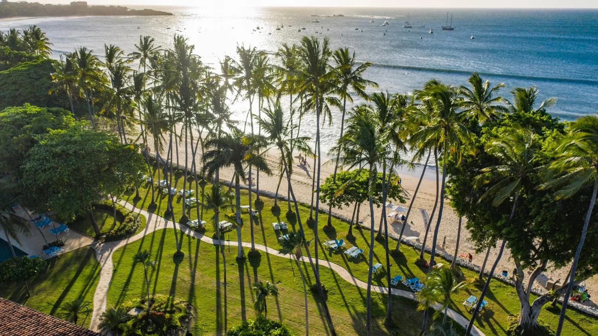 Palm gardens running down to the sand and the bay at a beachfront hotel in Tamarindo, Costa Rica