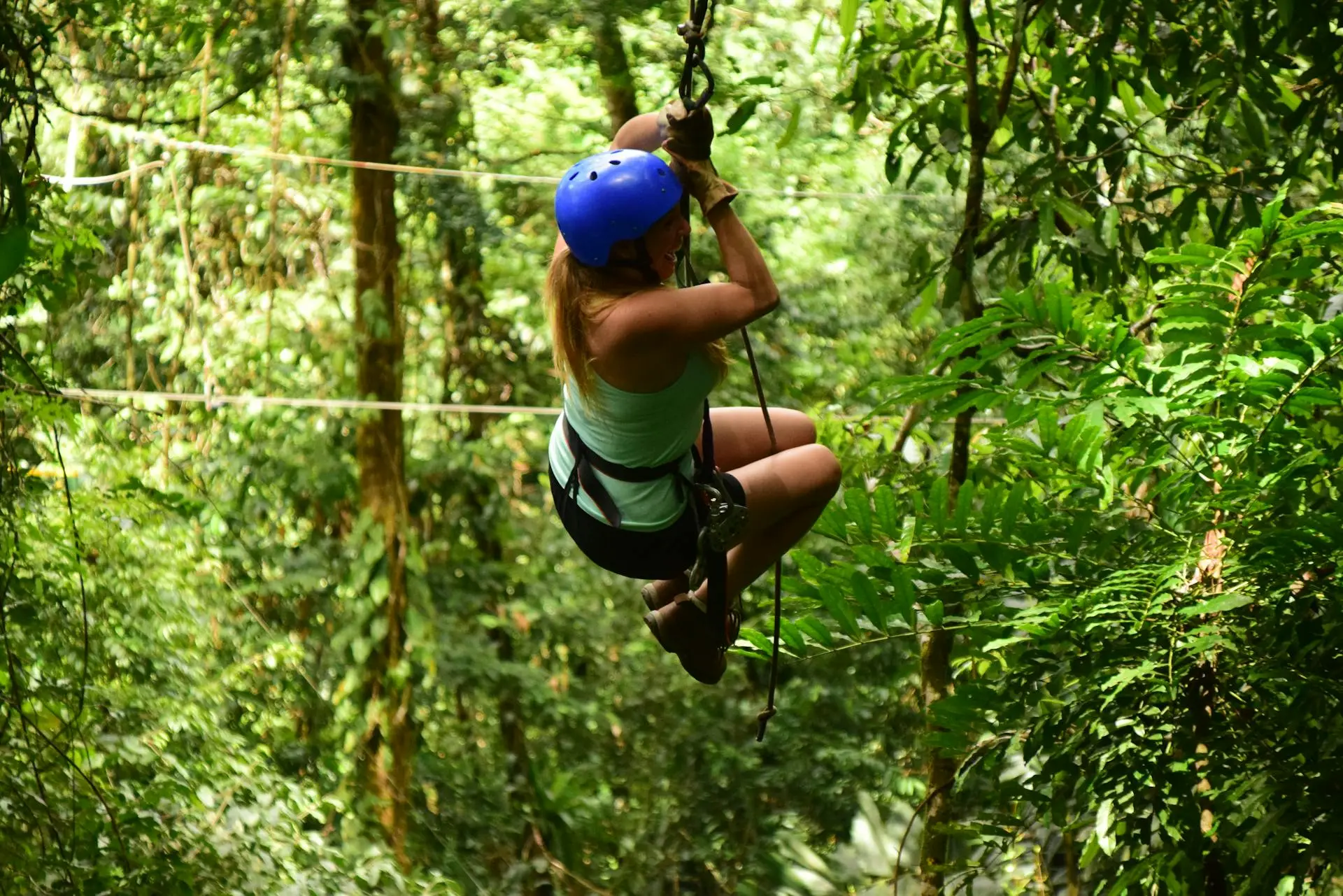 Viajero en tirolesa sobre el dosel del bosque seco tropical en las colinas detrás de Tamarindo, Guanacaste